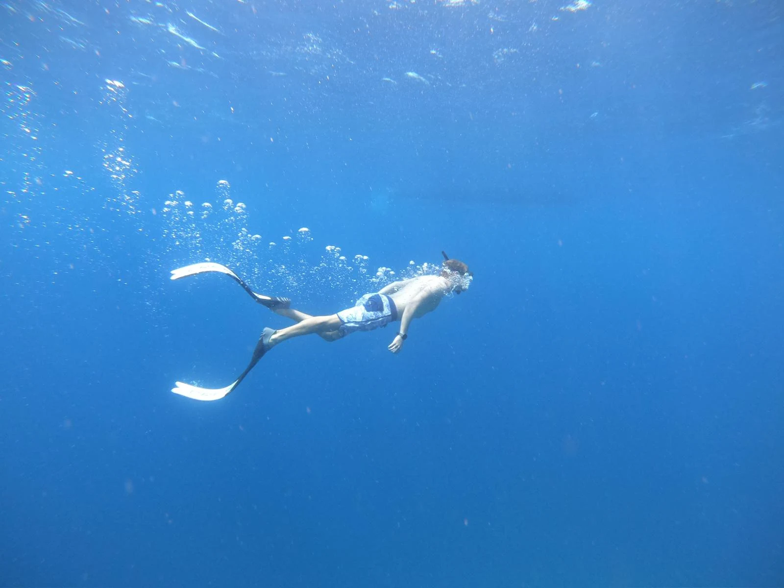James freediving in blue water.